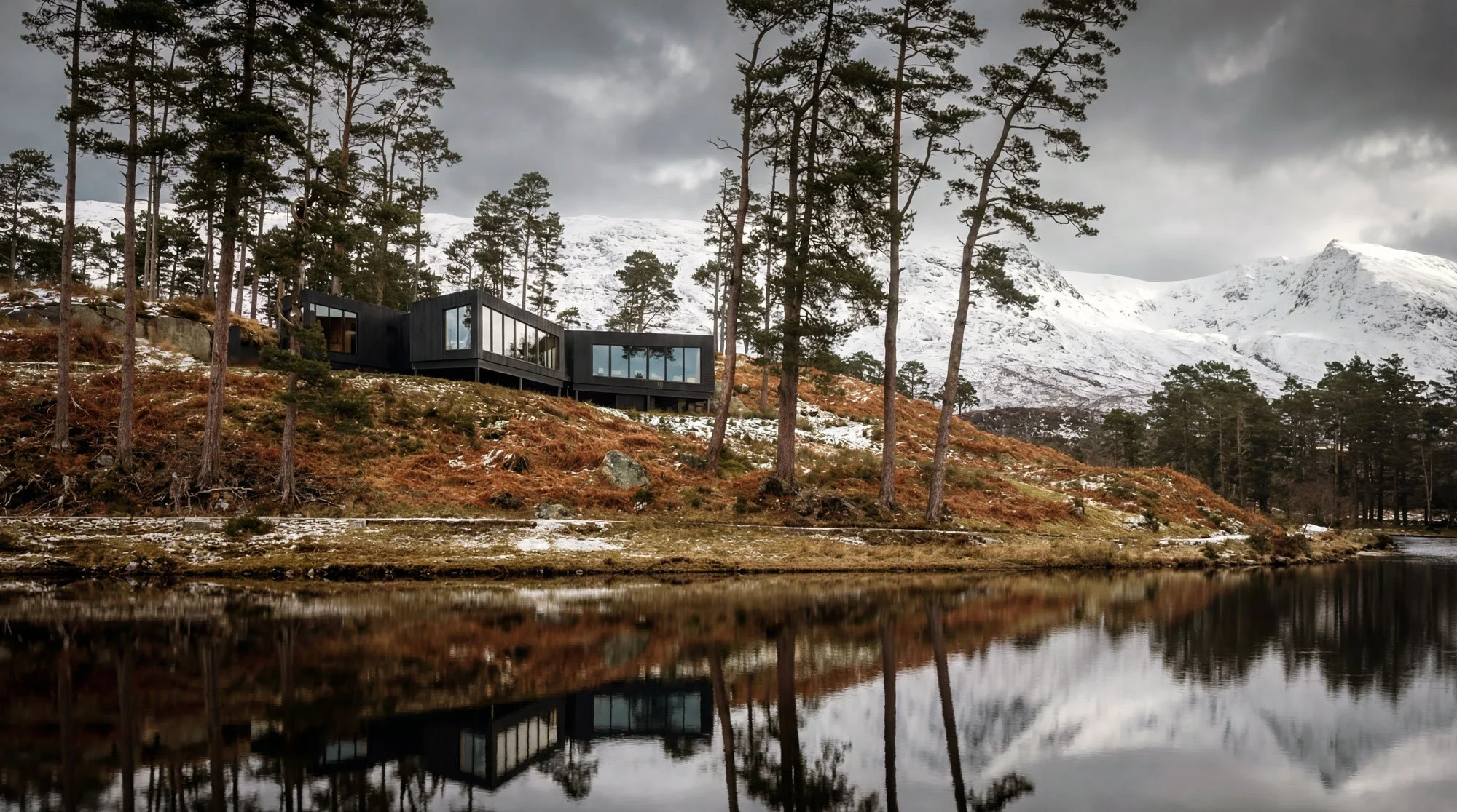 Cabin by a lake in pine forest